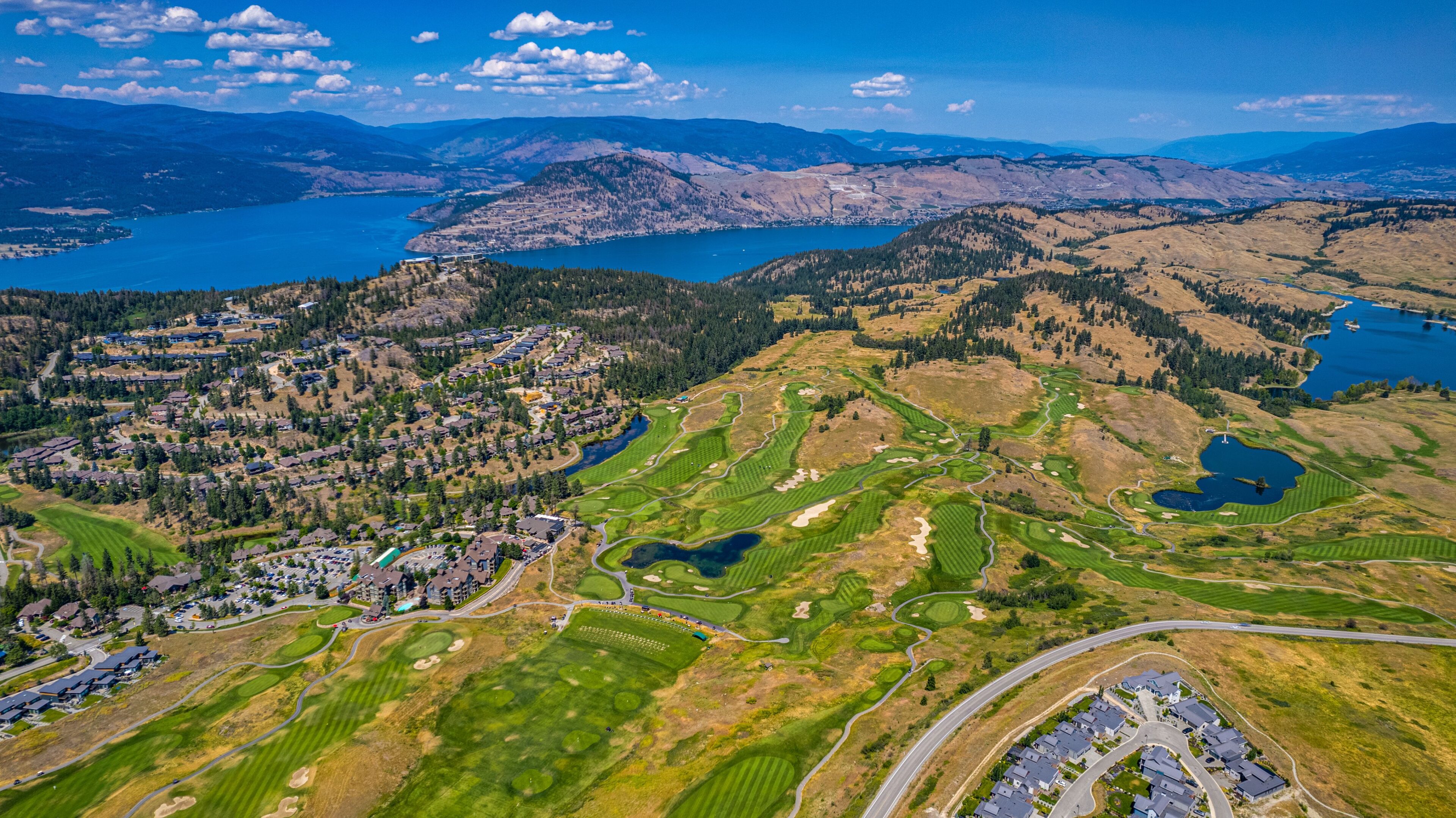 A view of a golf course and lake from above.